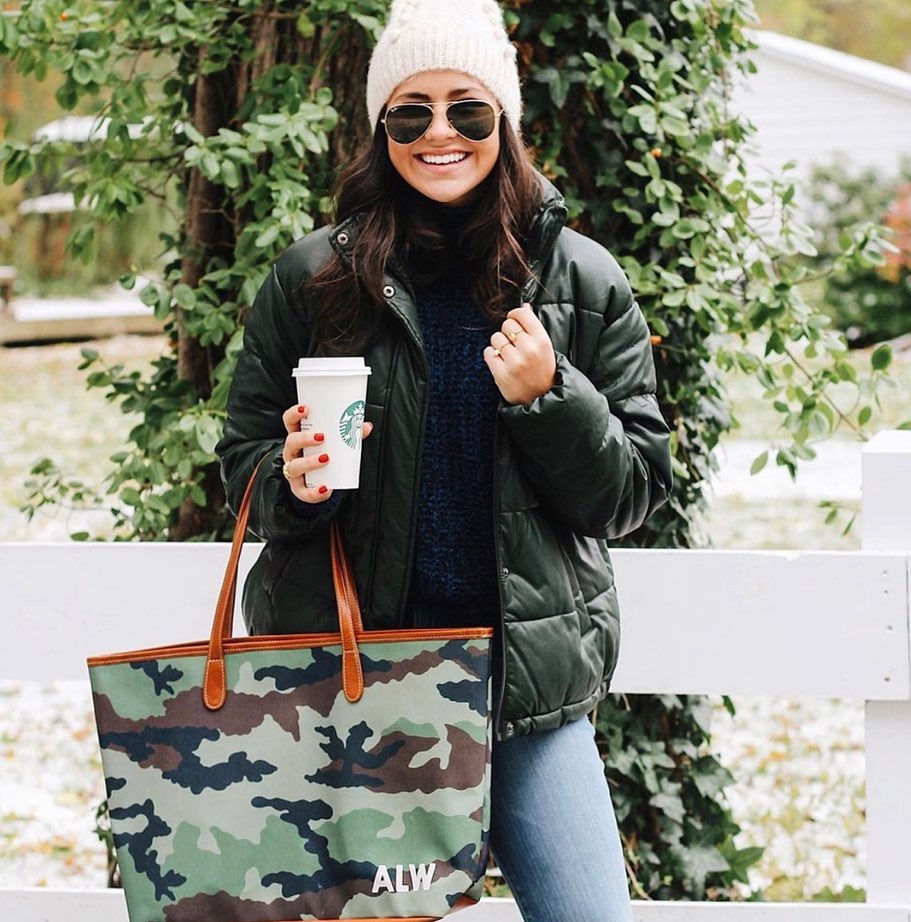 Woman holding a monogrammed tote bag with zipper